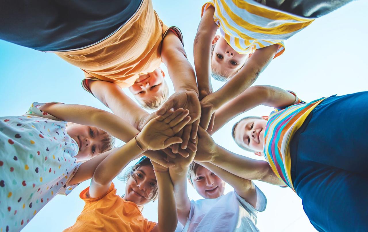 Children stacking their hands together in a circle